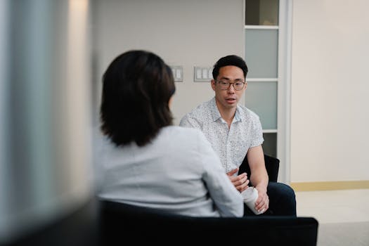 Two colleagues having a focused conversation in an office setting.